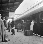 859240 Afbeelding van reizigers op het 3e perron van het N.S.-station Amsterdam C.S. te Amsterdam, bij een ...